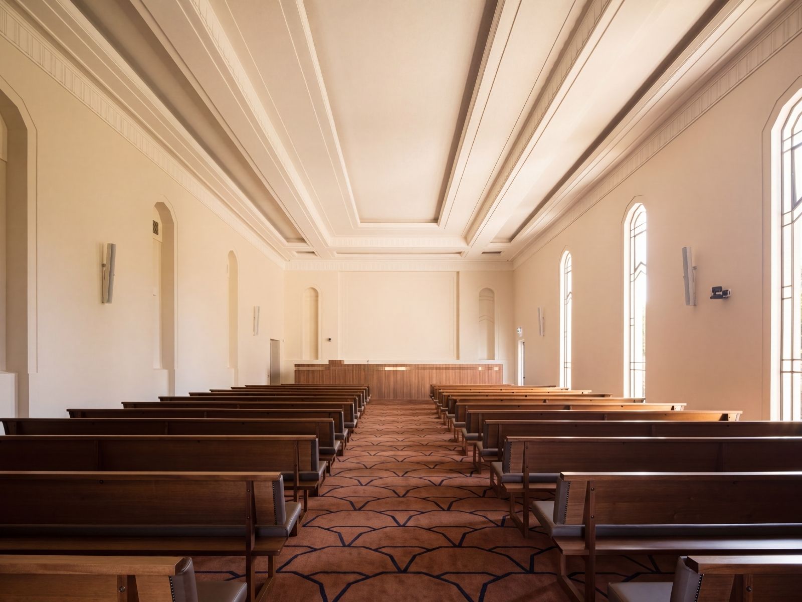 Dark timber pews and catafalque inside Boyd Chapel beneath the coffered ceiling