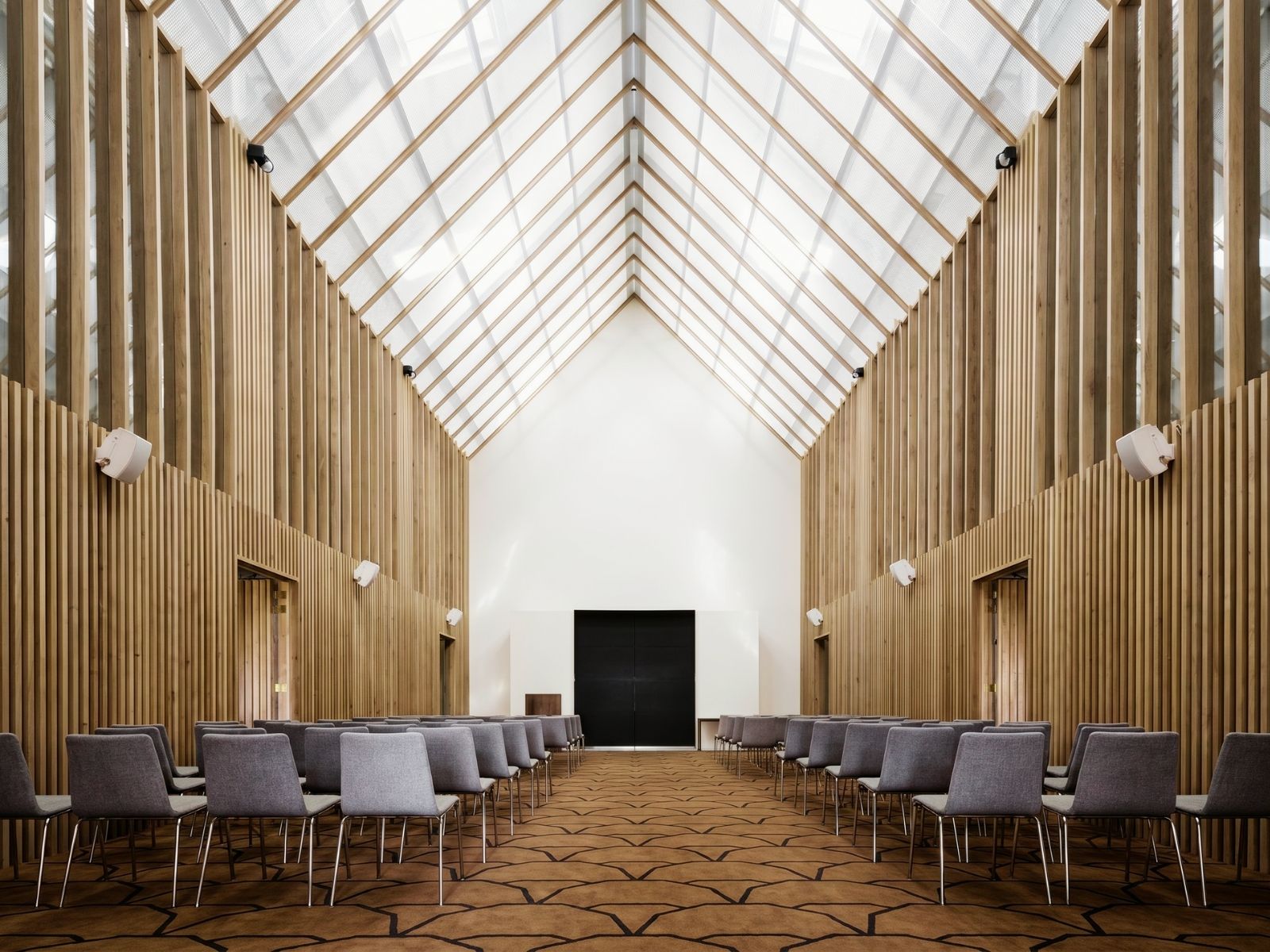 The Atrium at Springvale with rows of chairs beneath the glass roof and timber batten walls