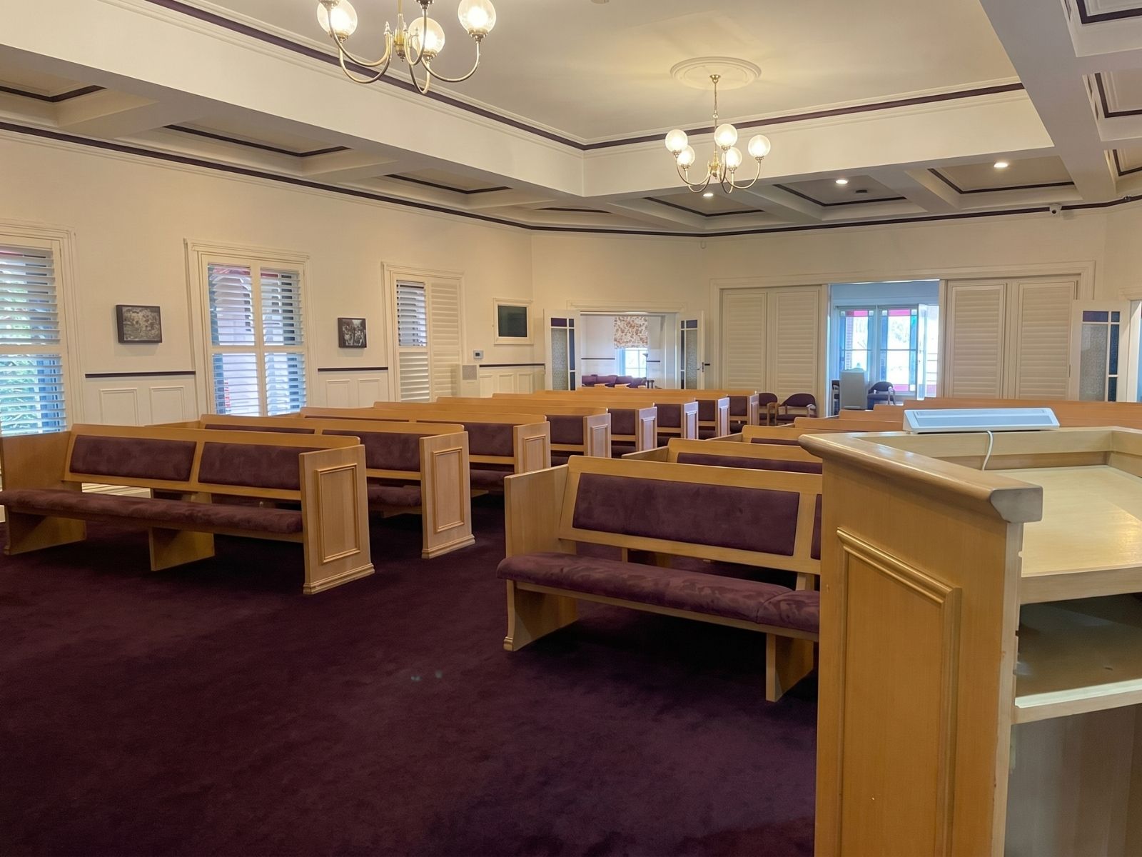 Federation Chapel interior from the lectern, timber pews and louvred doors to the lounge beyond