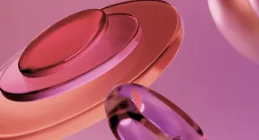 Glossy translucent rings in shades of red and purple floating on a pink background.