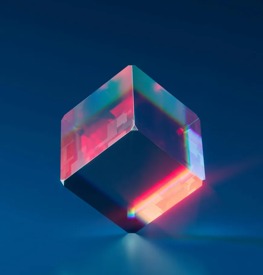 Transparent glass cube with pink and blue light reflections floating above a dark blue surface.