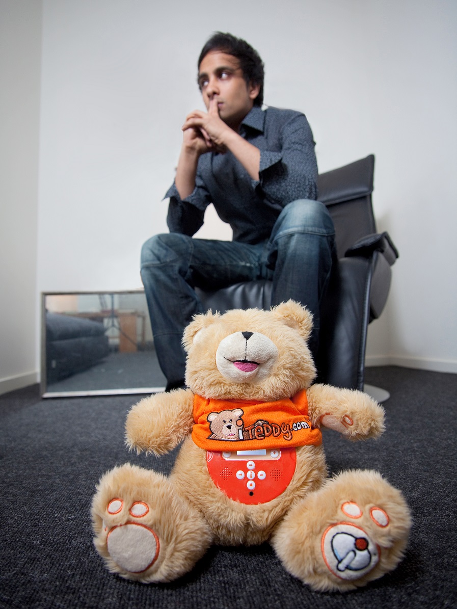 Imran Hakim sitting behind a branded iTeddy teddy bear during a promotional photoshoot.