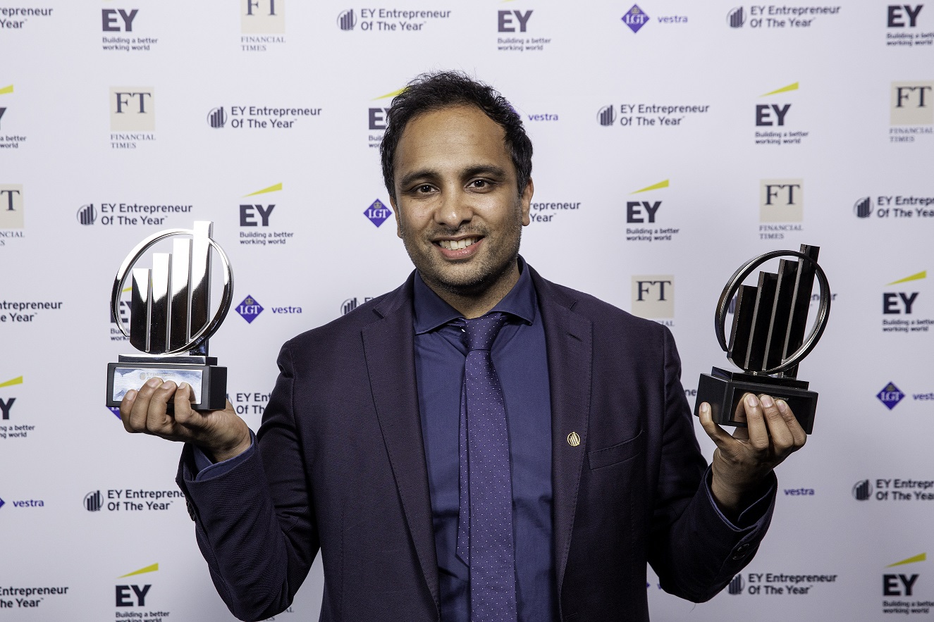 Imran Hakim holding two EY Entrepreneur of the Year awards at the awards ceremony.