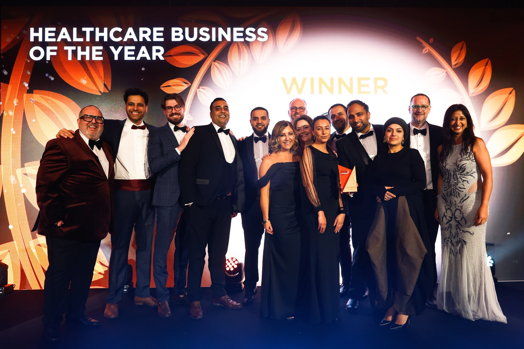 Hakim Group team celebrating after winning Healthcare Business of the Year at an awards ceremony.