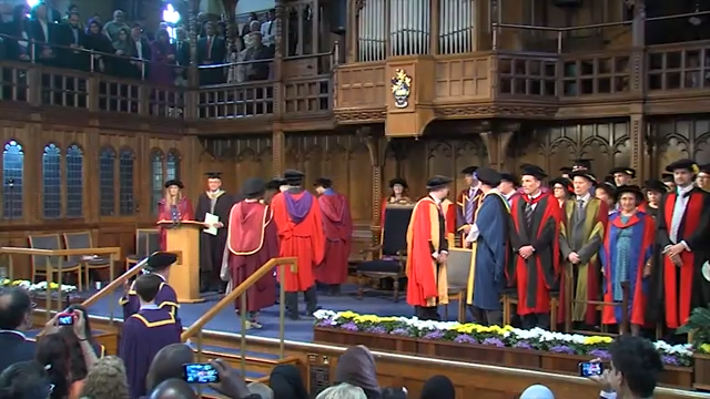 Imran Hakim attending a formal graduation ceremony with academic officials in ceremonial robes.