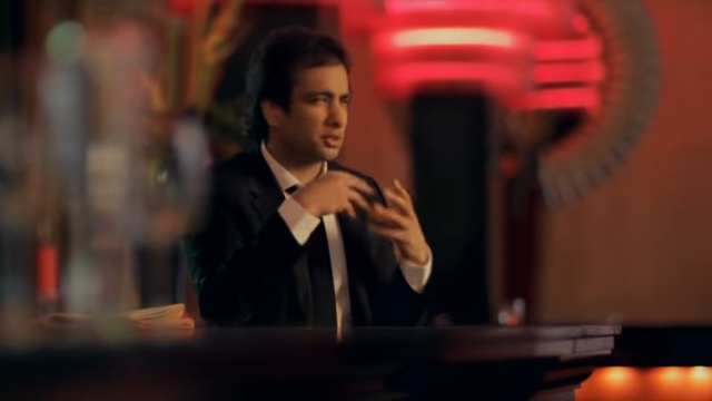 Imran Hakim speaking during an interview in a stylish restaurant or lounge.