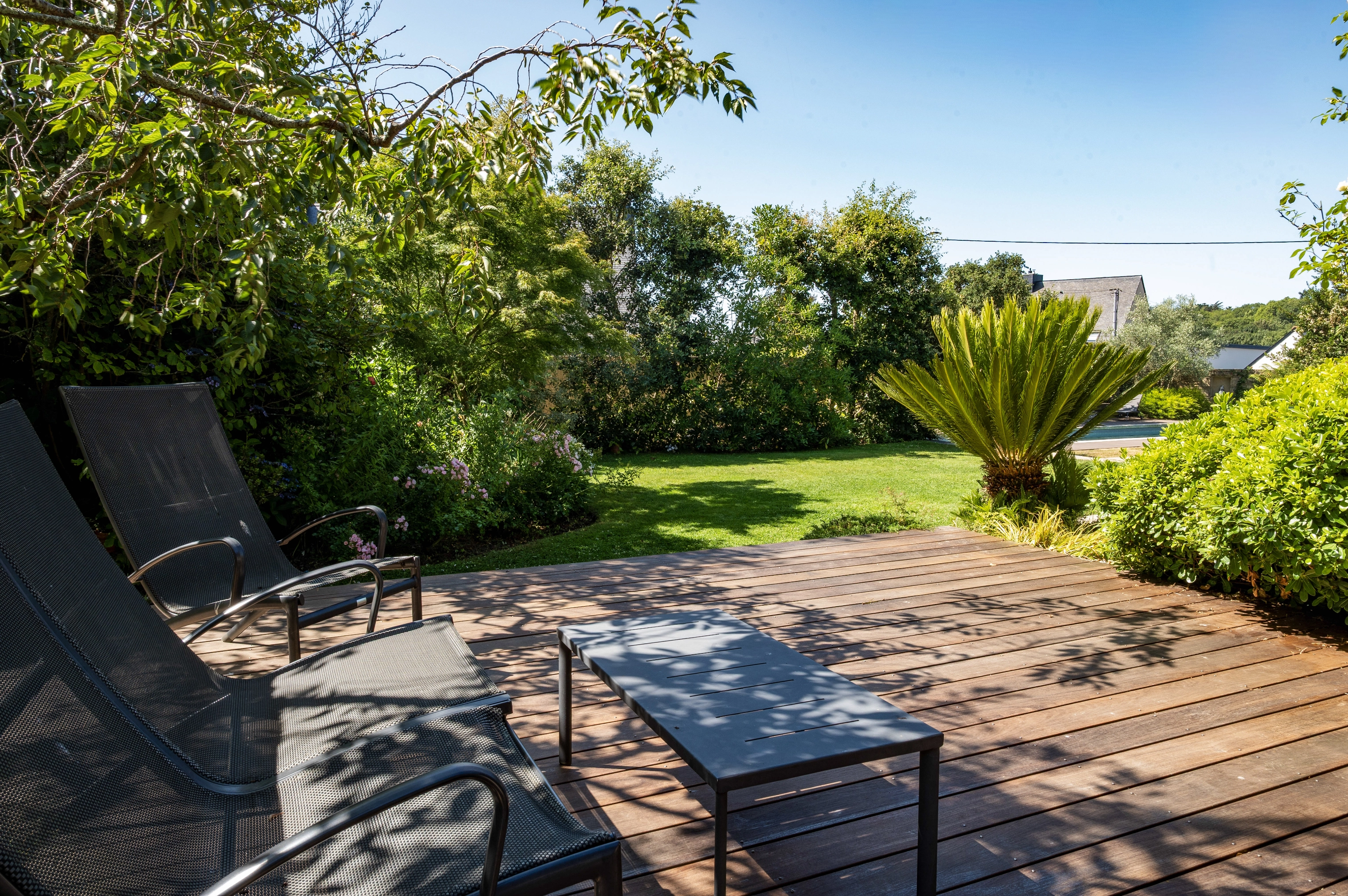 Terrasse à l'ombre d'un arbre dans un jardin à Ploemeur
