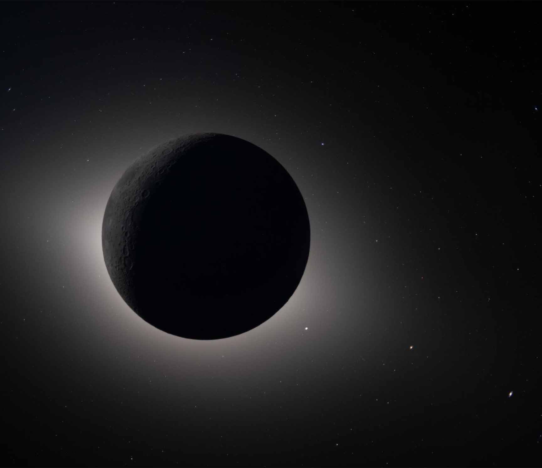 Kuun pimennys, missä Kuu on täysin varjossa ja juuri alkamassa paljastaa aavistuksen auringonvaloa reunallaan tähtitaivaan alla.