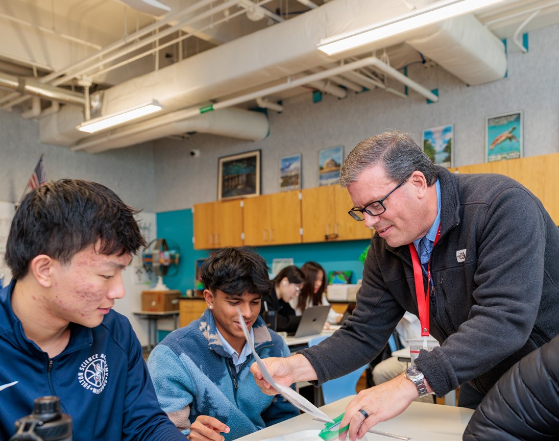 An FSA educator guiding older students through their work