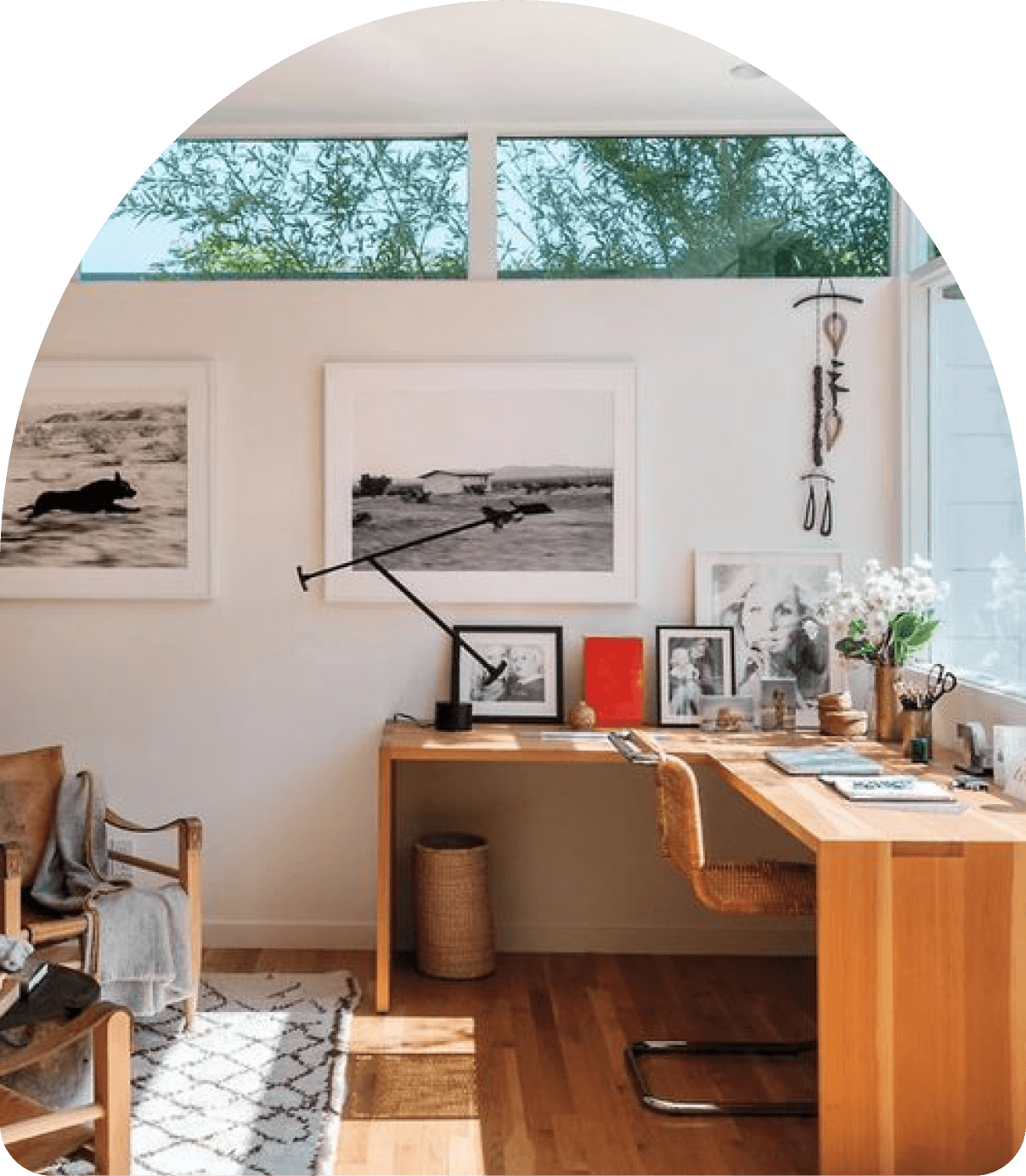 A room with a desk, chair and pictures on the wall.