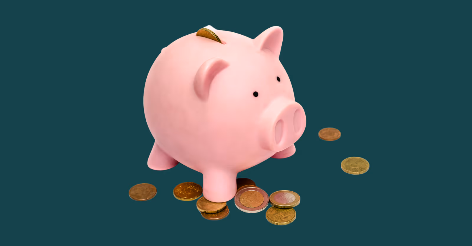 Pink piggy bank with coins on dark green background.