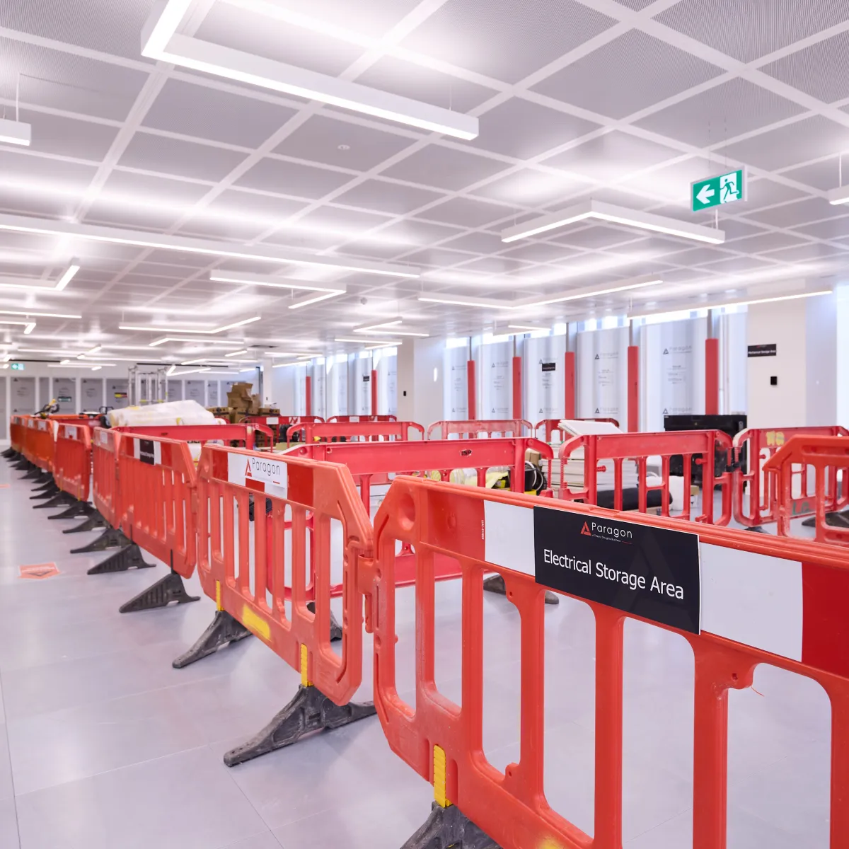 Bright open construction area lined with orange safety barriers.