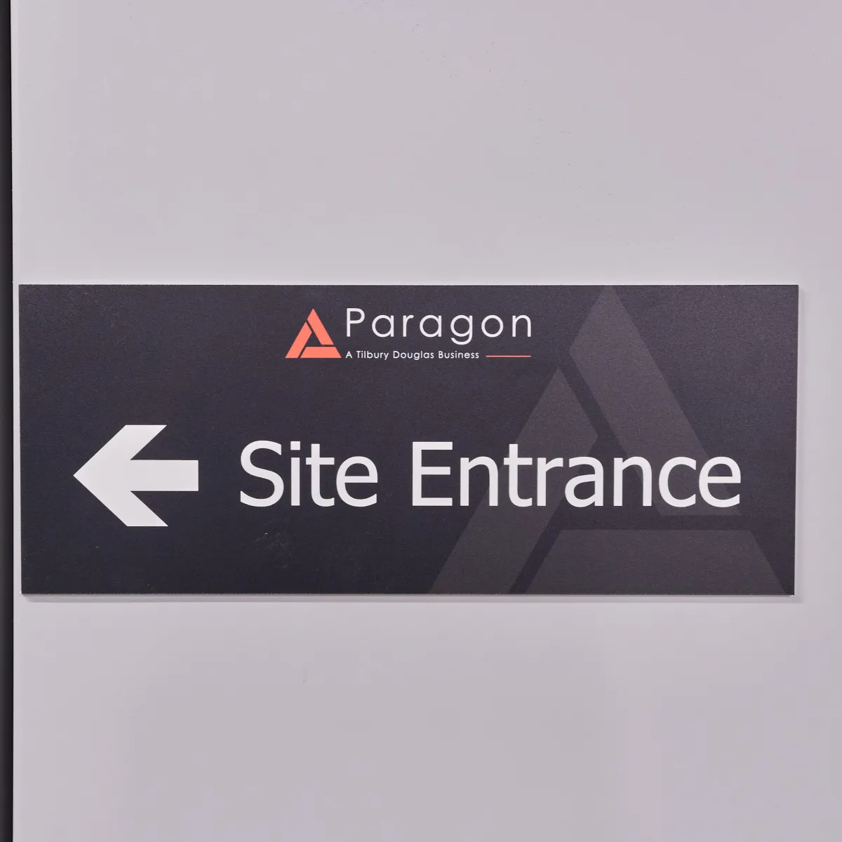 Paragon site entrance sign with a left-pointing arrow.