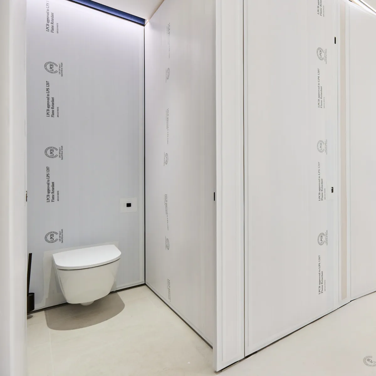 White washroom cubicles with a visible toilet and minimalist finishes.