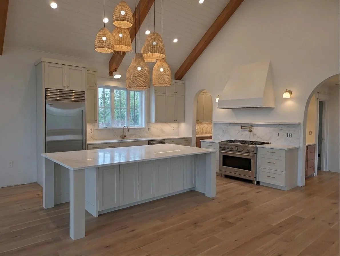 Finished kitchen remodel with a vaulted ceiling, woven rattan pendants, a white Shaker island and a pro-style range