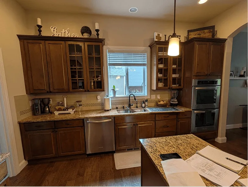Before: Bonney Lake kitchen with dark wood cabinets, granite counters and a small island