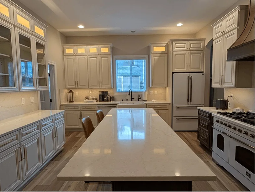 After: the same Bonney Lake kitchen with painted cabinets, lit glass uppers and a long island