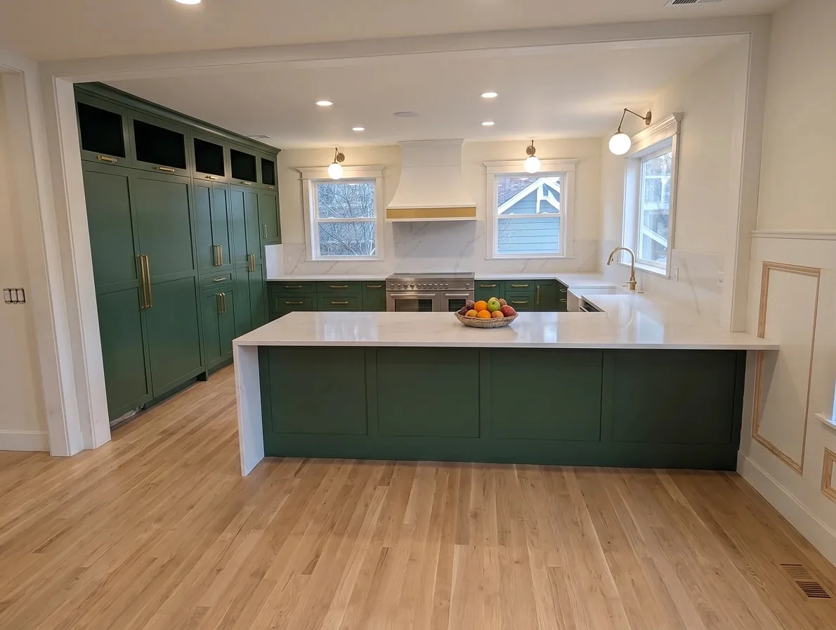 Deep green Shaker kitchen with brass hardware and a waterfall peninsula