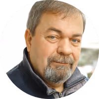 Portrait of a middle-aged man with short gray hair, beard, and mustache wearing a navy jacket.