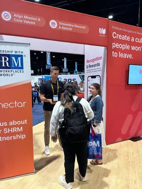 A group of people standing around a booth.