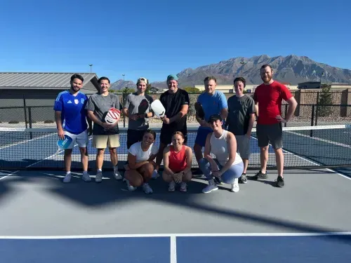 A group of people standing on top of a tennis court.