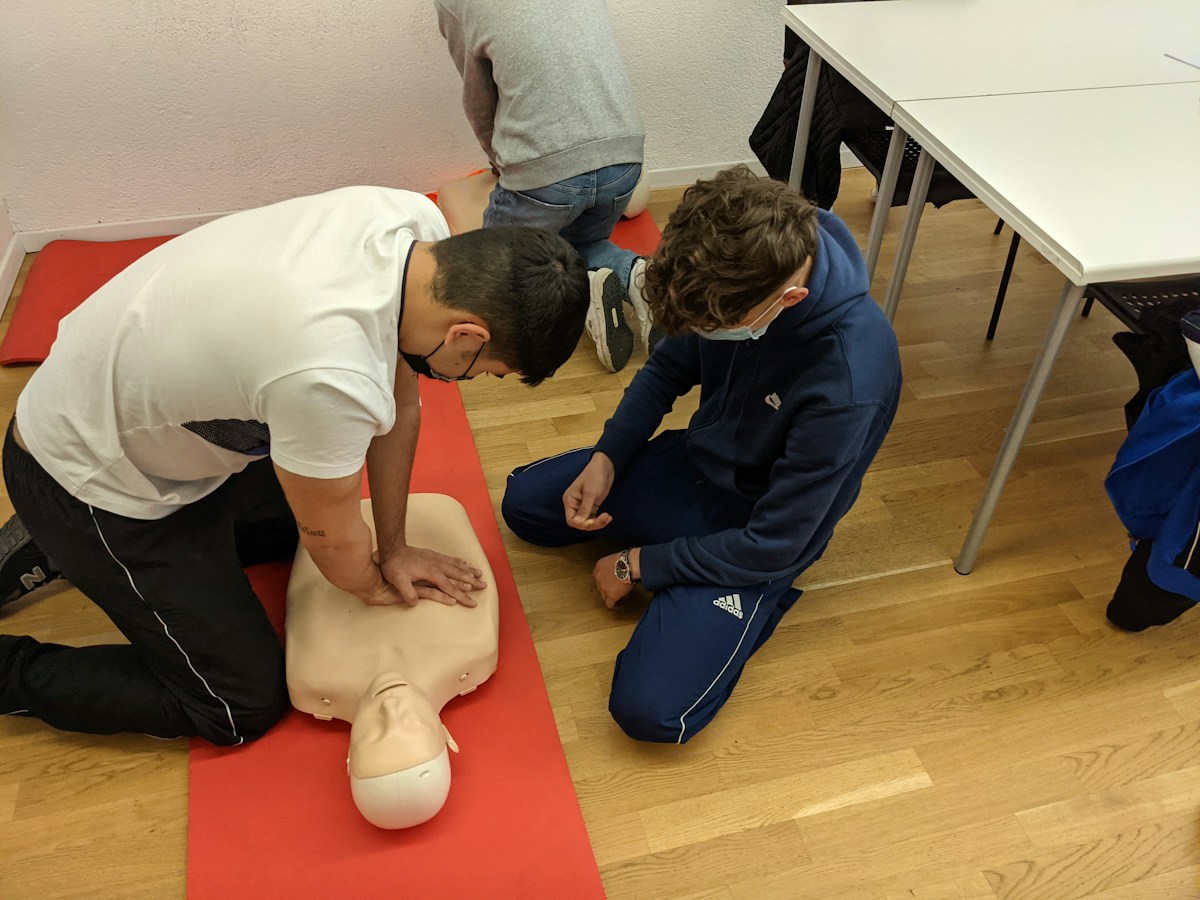 Two participants practicing CPR on a training manikin