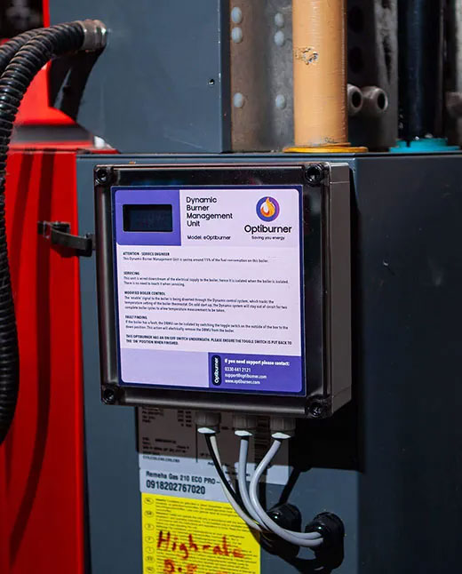Dynamic Burner Management Unit labeled 'Optiburner' mounted on industrial equipment with connecting cables.