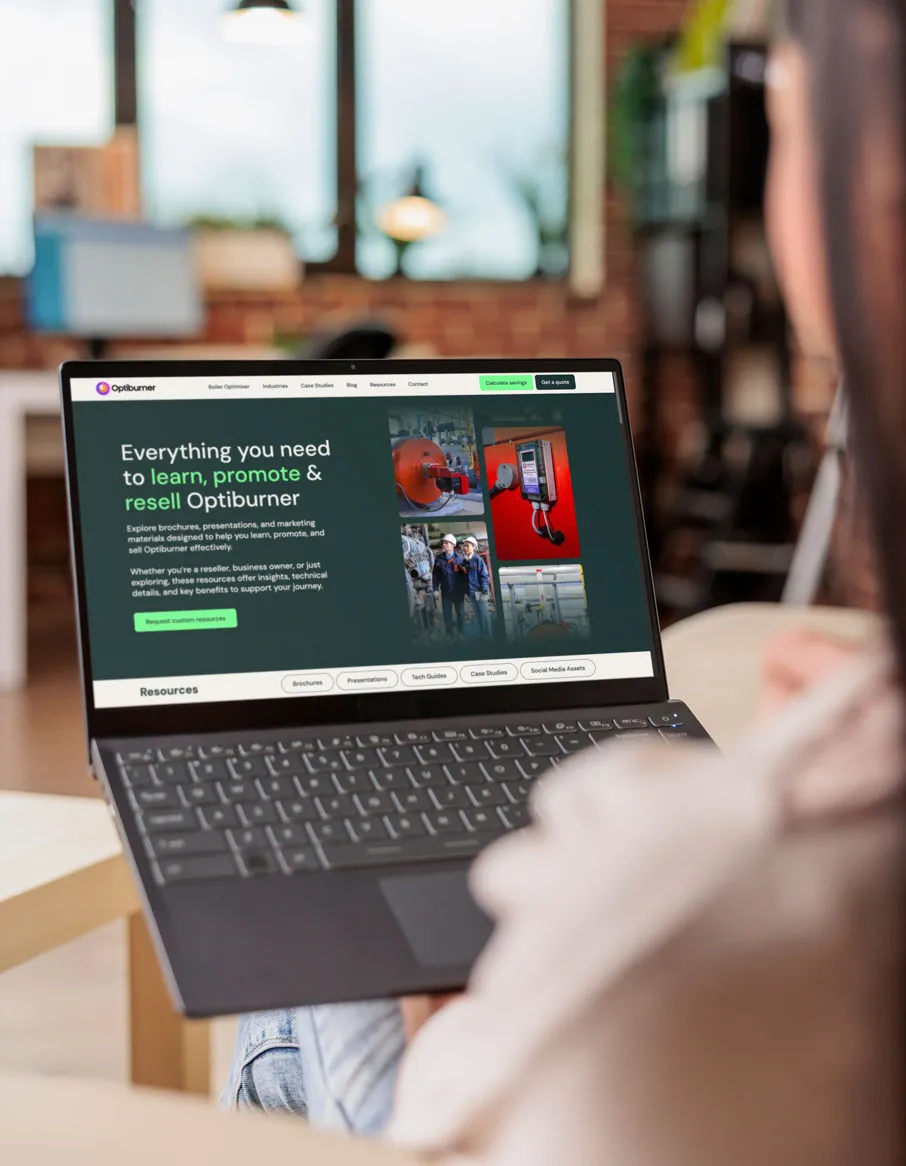 Person holding a laptop displaying the Optiburner website with marketing resources for learning, promoting, and reselling.