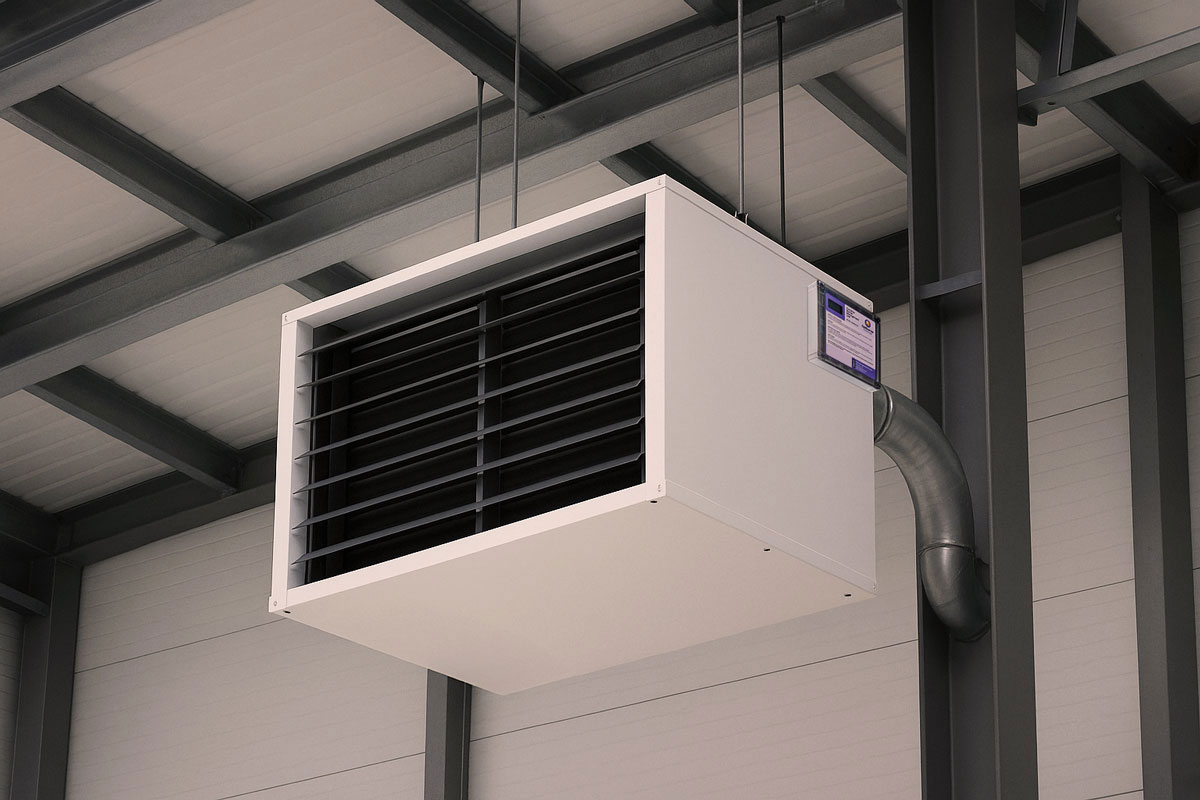 White rectangular industrial warm air heater unit suspended from a ceiling in a warehouse.