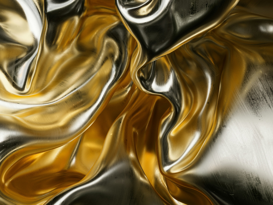 Abstract close-up of flowing gold and silver metallic fabric