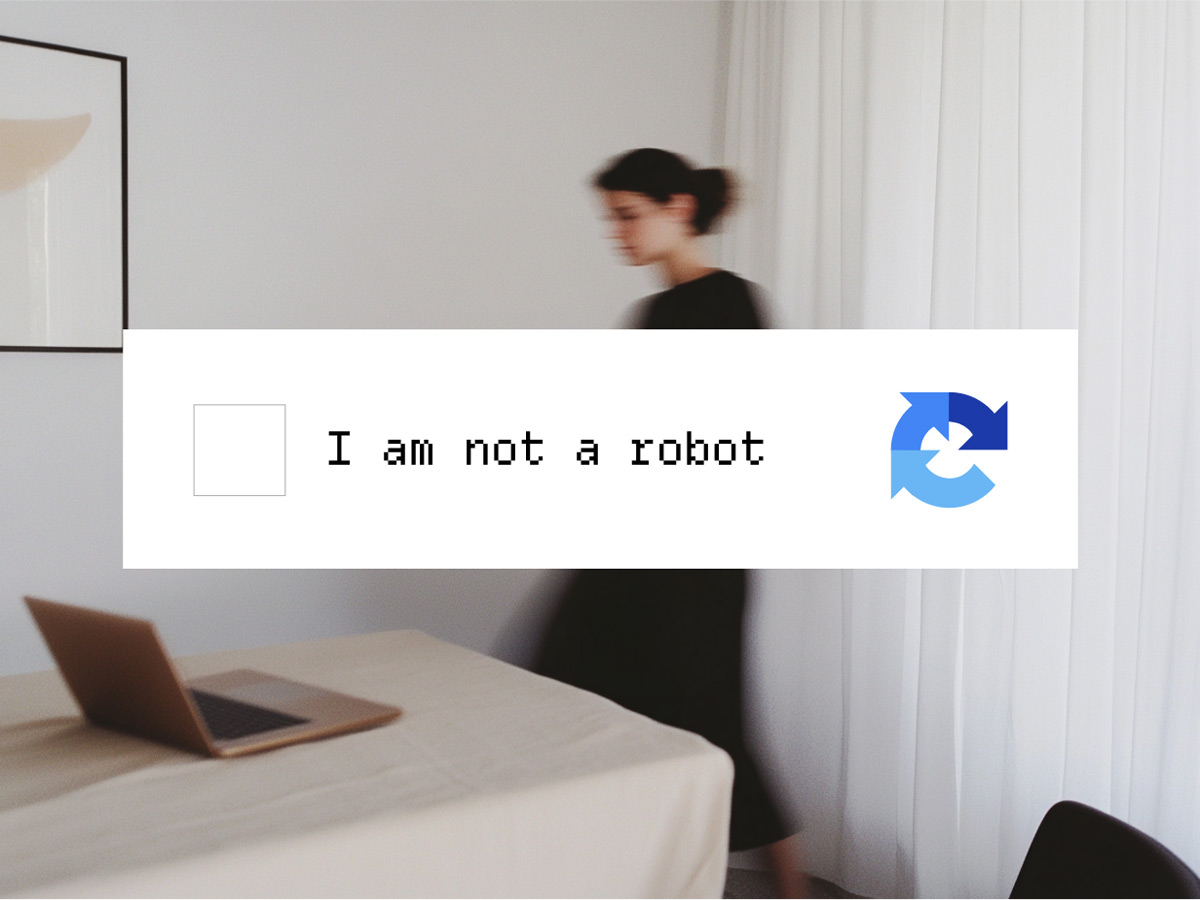 “I am not a robot” CAPTCHA checkbox over a photo of a person walking past a desk