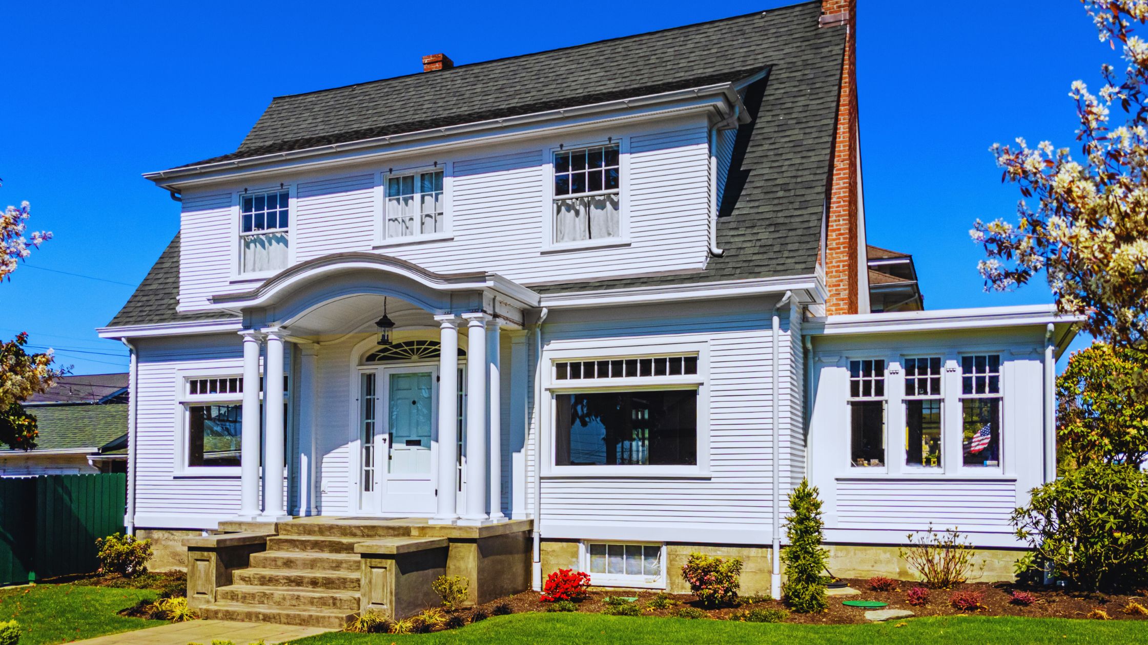 "A modern suburban home with a spacious driveway and double garage, set against a vibrant sunset sky, featuring well-maintained landscaping and a cozy porch light illuminating the entryway.