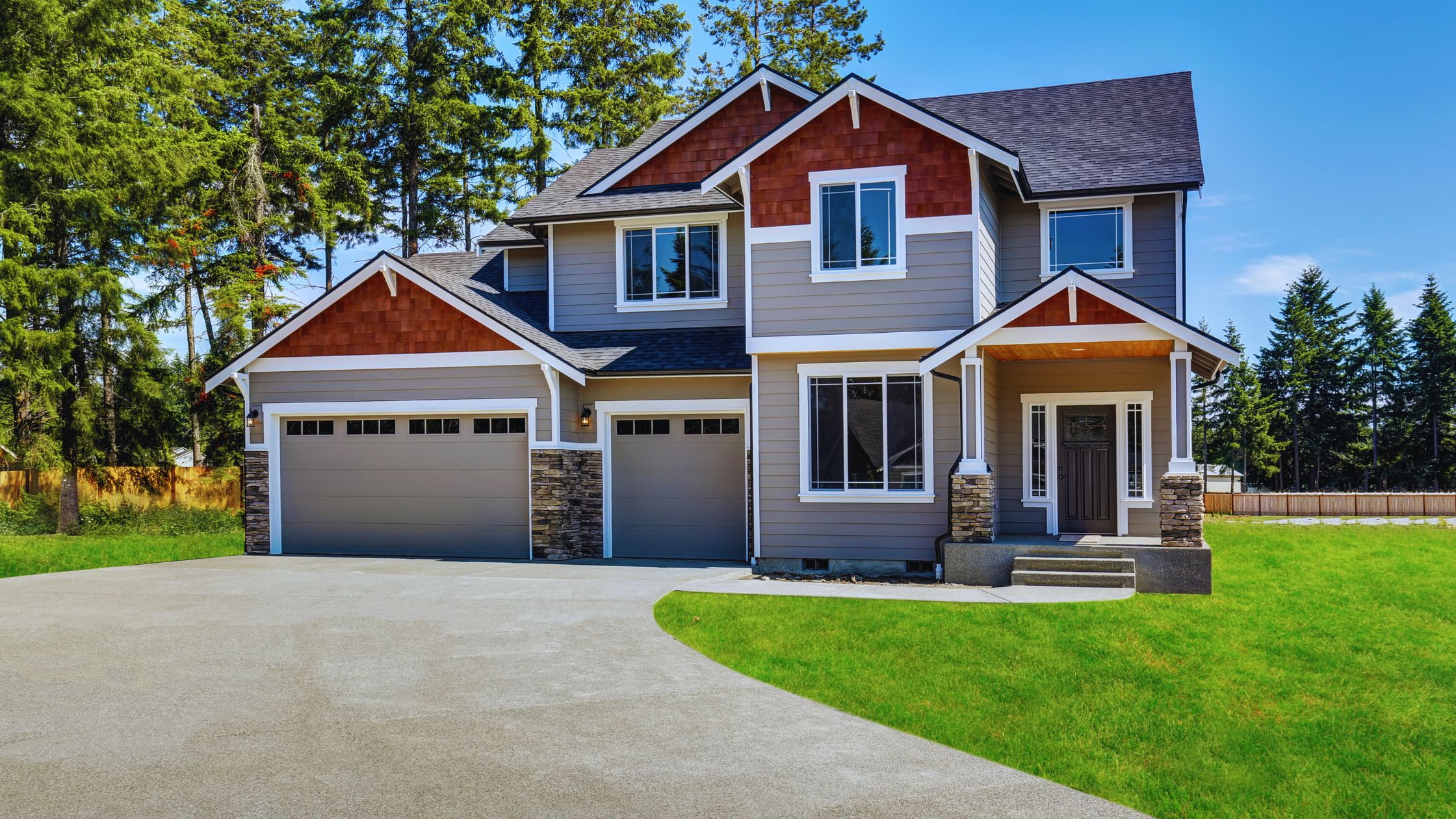 "A modern suburban home with a spacious driveway and double garage, set against a vibrant sunset sky, featuring well-maintained landscaping and a cozy porch light illuminating the entryway.