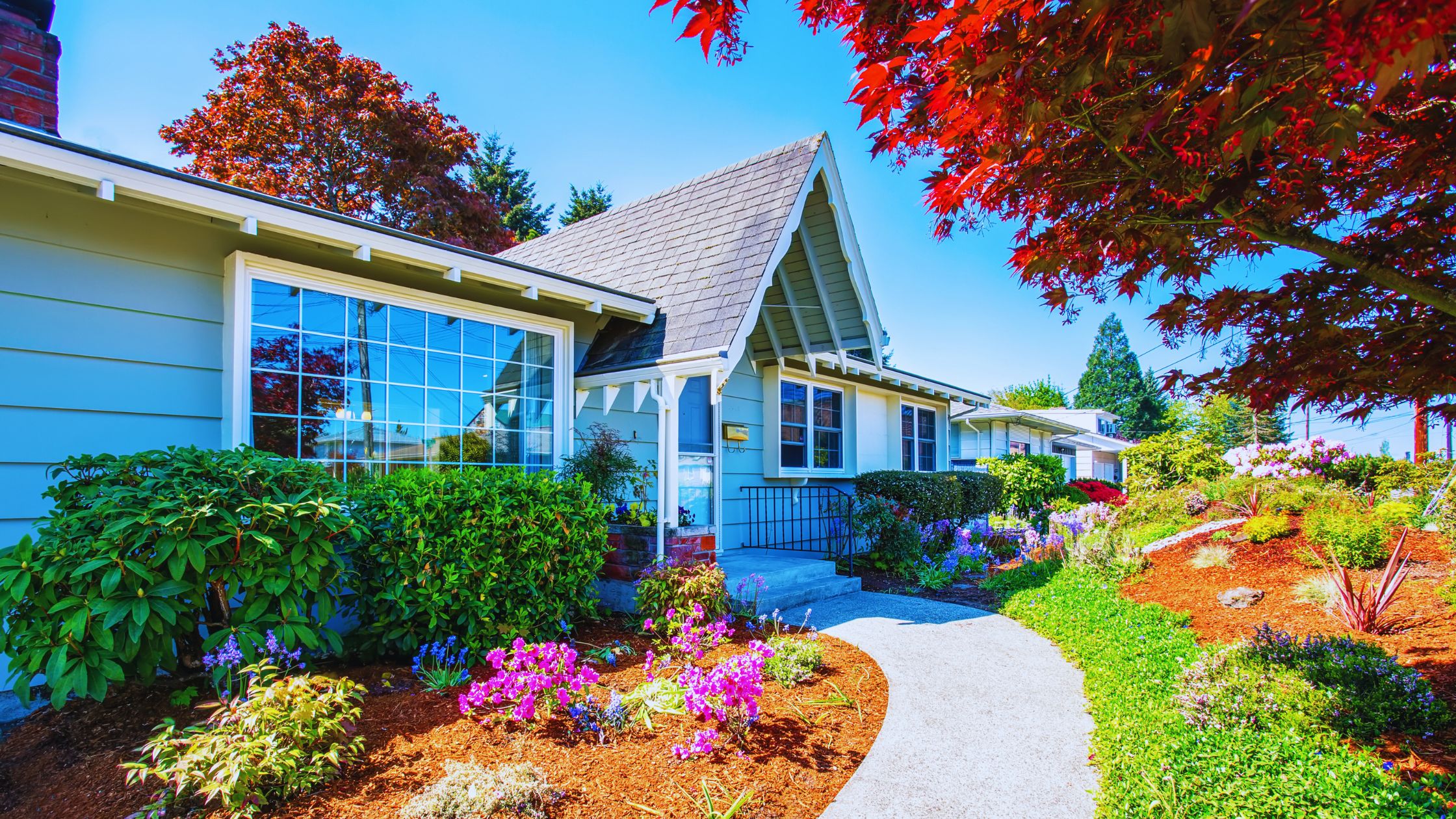 "A modern suburban home with a spacious driveway and double garage, set against a vibrant sunset sky, featuring well-maintained landscaping and a cozy porch light illuminating the entryway.