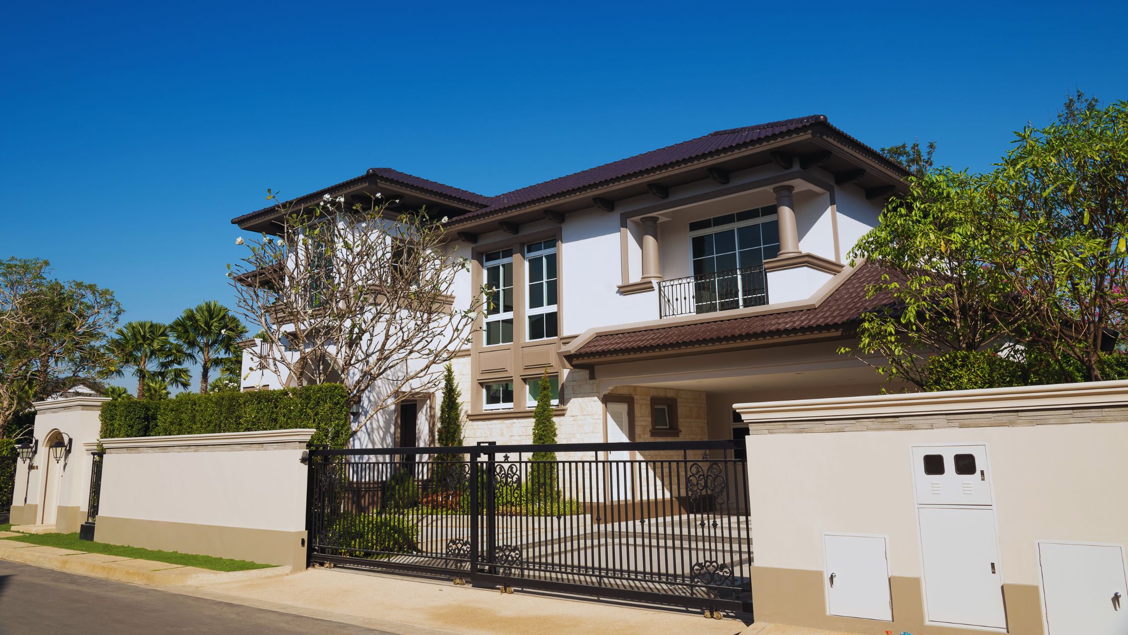 "A modern suburban home with a spacious driveway and double garage, set against a vibrant sunset sky, featuring well-maintained landscaping and a cozy porch light illuminating the entryway.