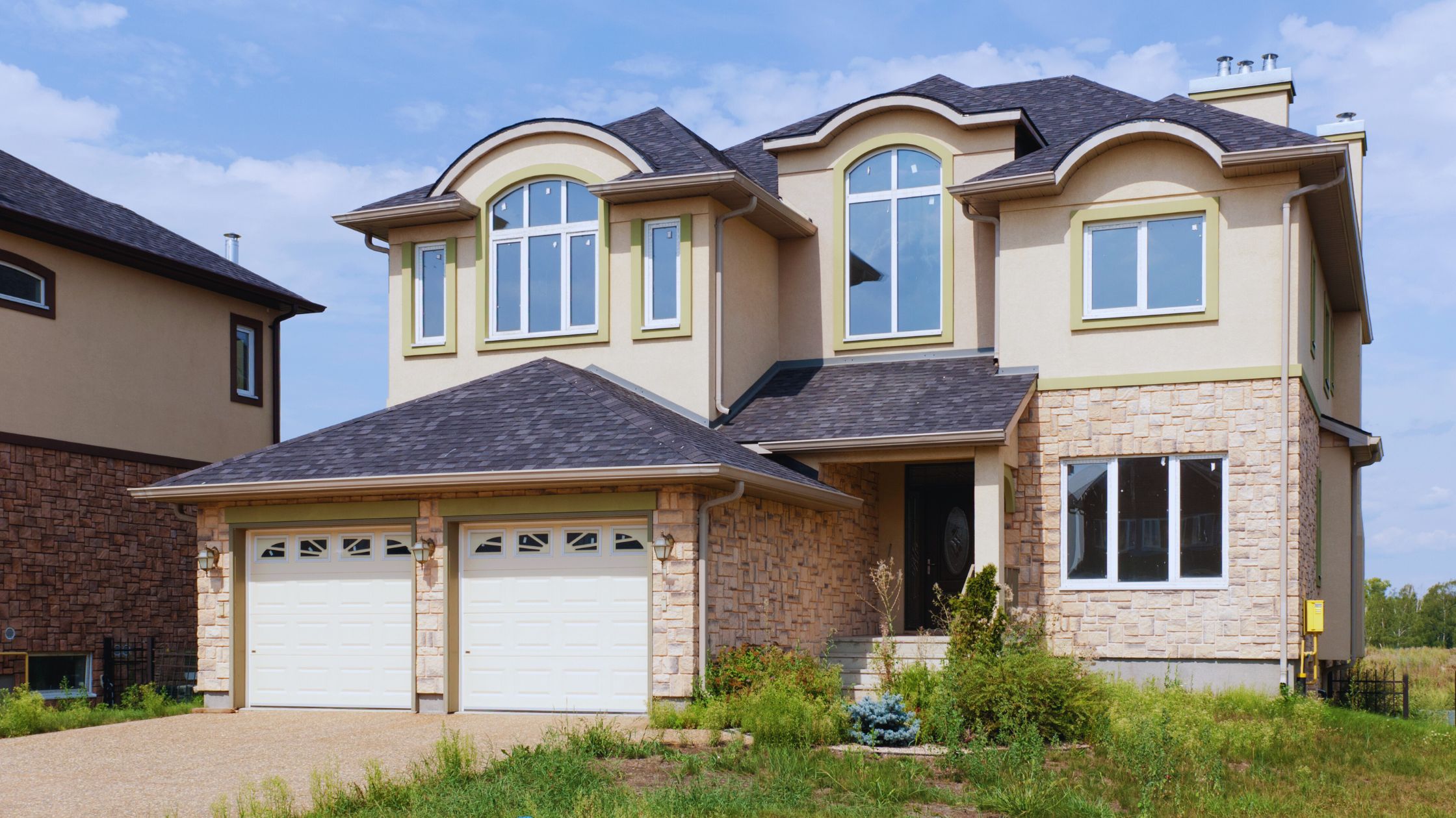 "A modern suburban home with a spacious driveway and double garage, set against a vibrant sunset sky, featuring well-maintained landscaping and a cozy porch light illuminating the entryway.