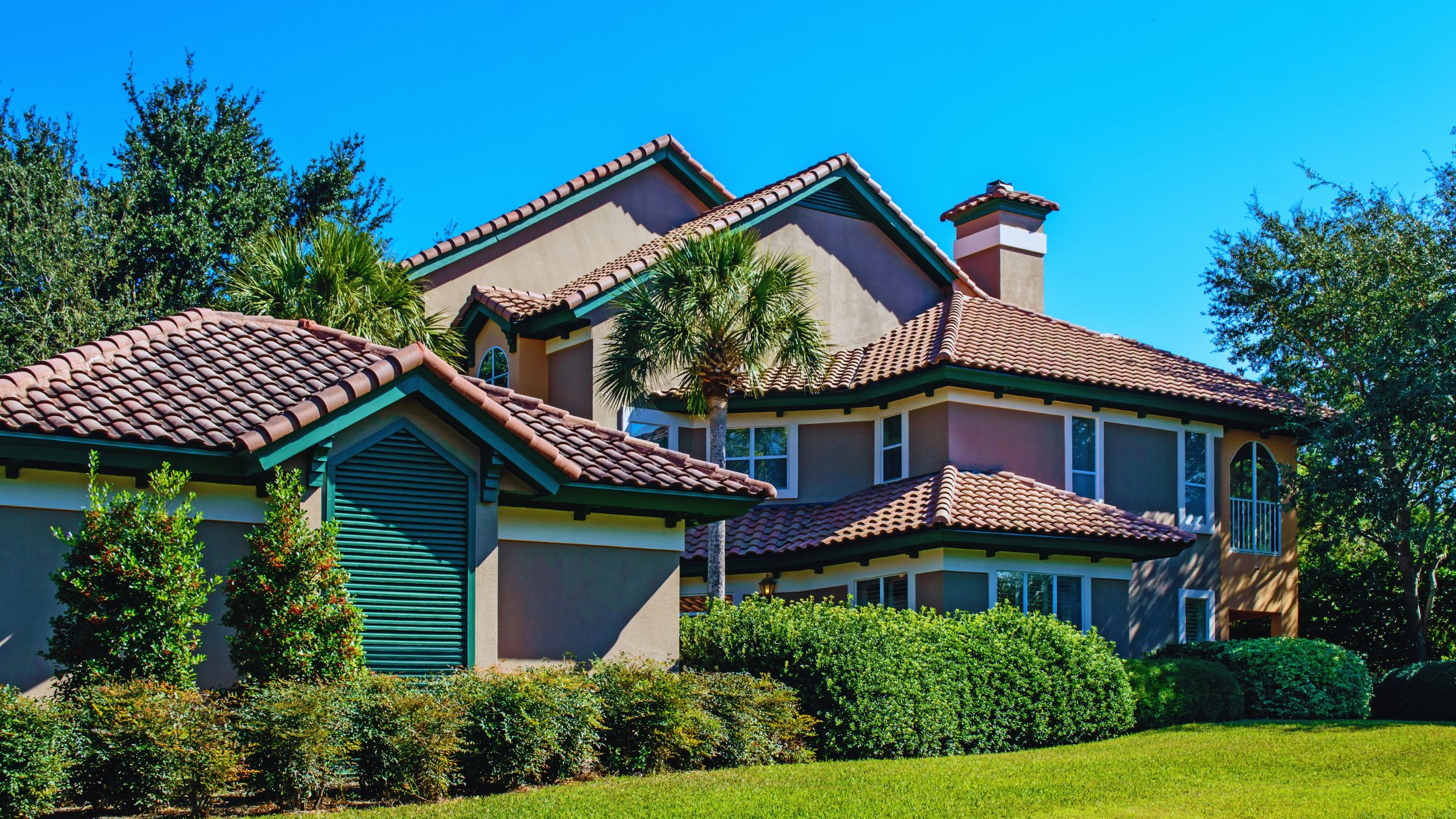 "A modern suburban home with a spacious driveway and double garage, set against a vibrant sunset sky, featuring well-maintained landscaping and a cozy porch light illuminating the entryway.