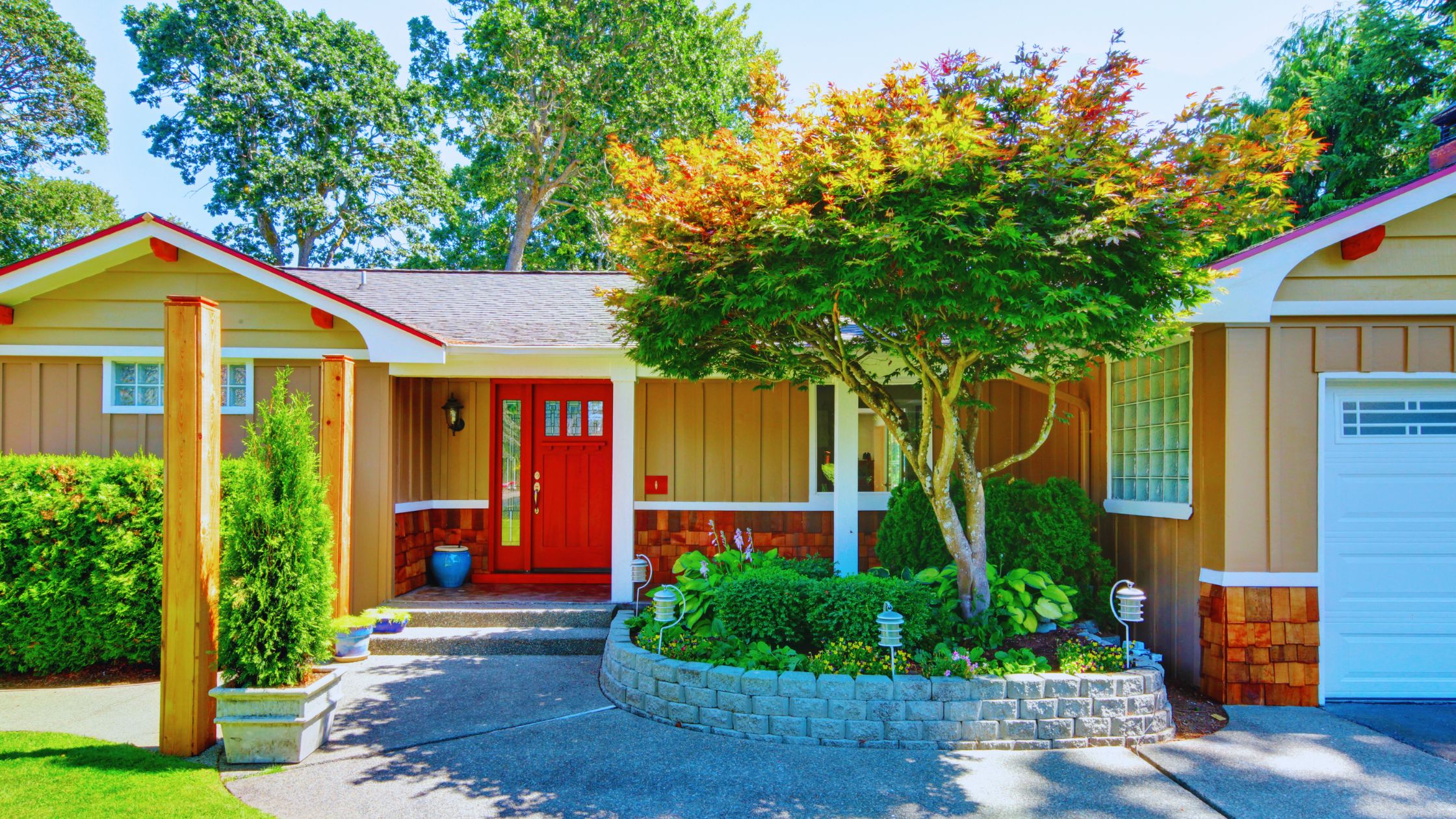 "A modern suburban home with a spacious driveway and double garage, set against a vibrant sunset sky, featuring well-maintained landscaping and a cozy porch light illuminating the entryway.