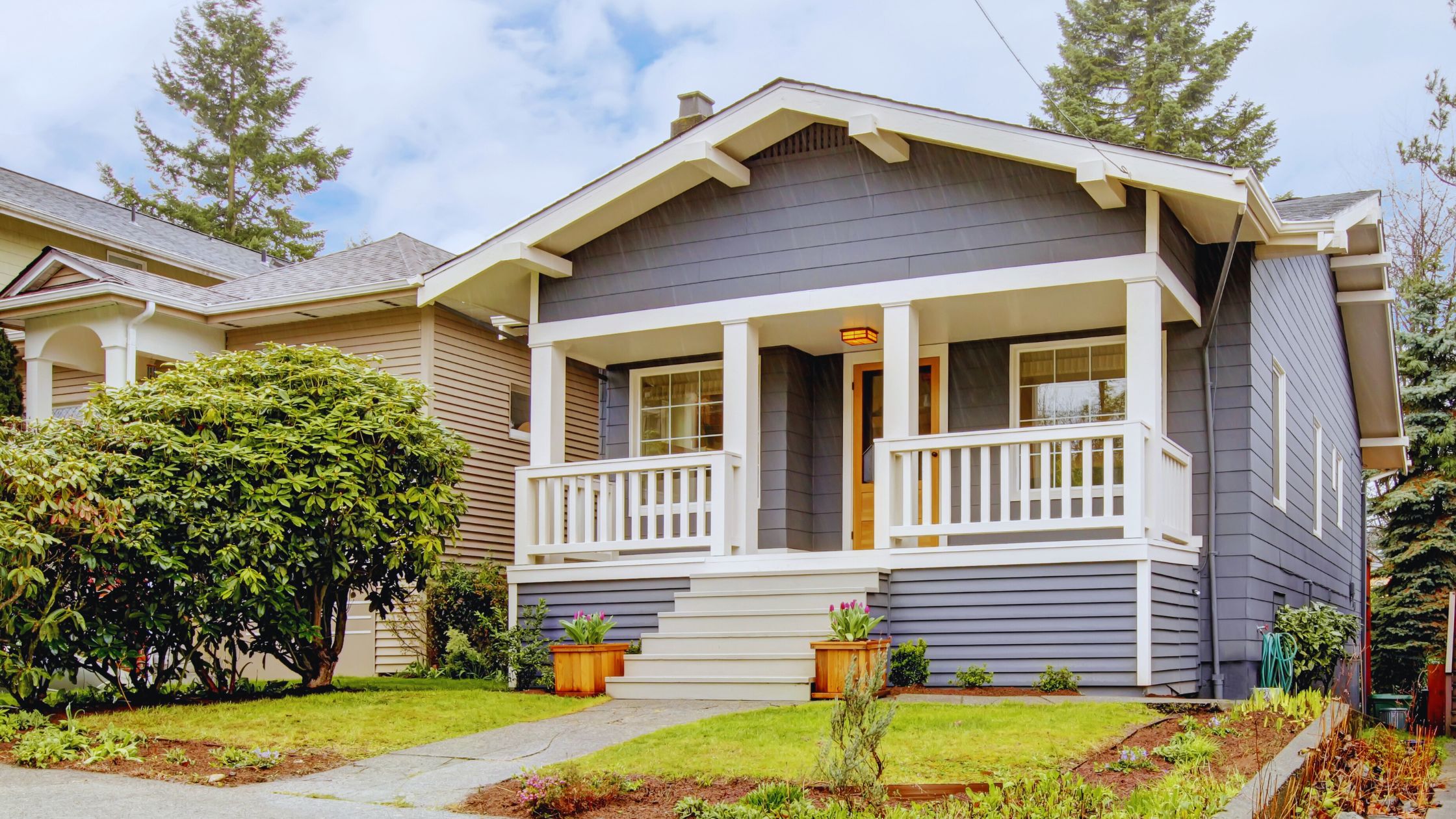 "A modern suburban home with a spacious driveway and double garage, set against a vibrant sunset sky, featuring well-maintained landscaping and a cozy porch light illuminating the entryway.