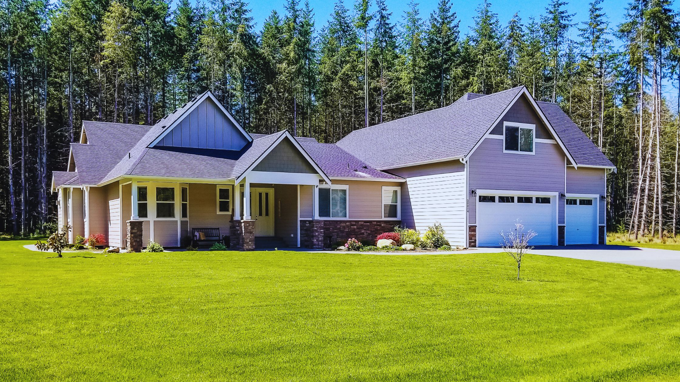 "A modern suburban home with a spacious driveway and double garage, set against a vibrant sunset sky, featuring well-maintained landscaping and a cozy porch light illuminating the entryway.