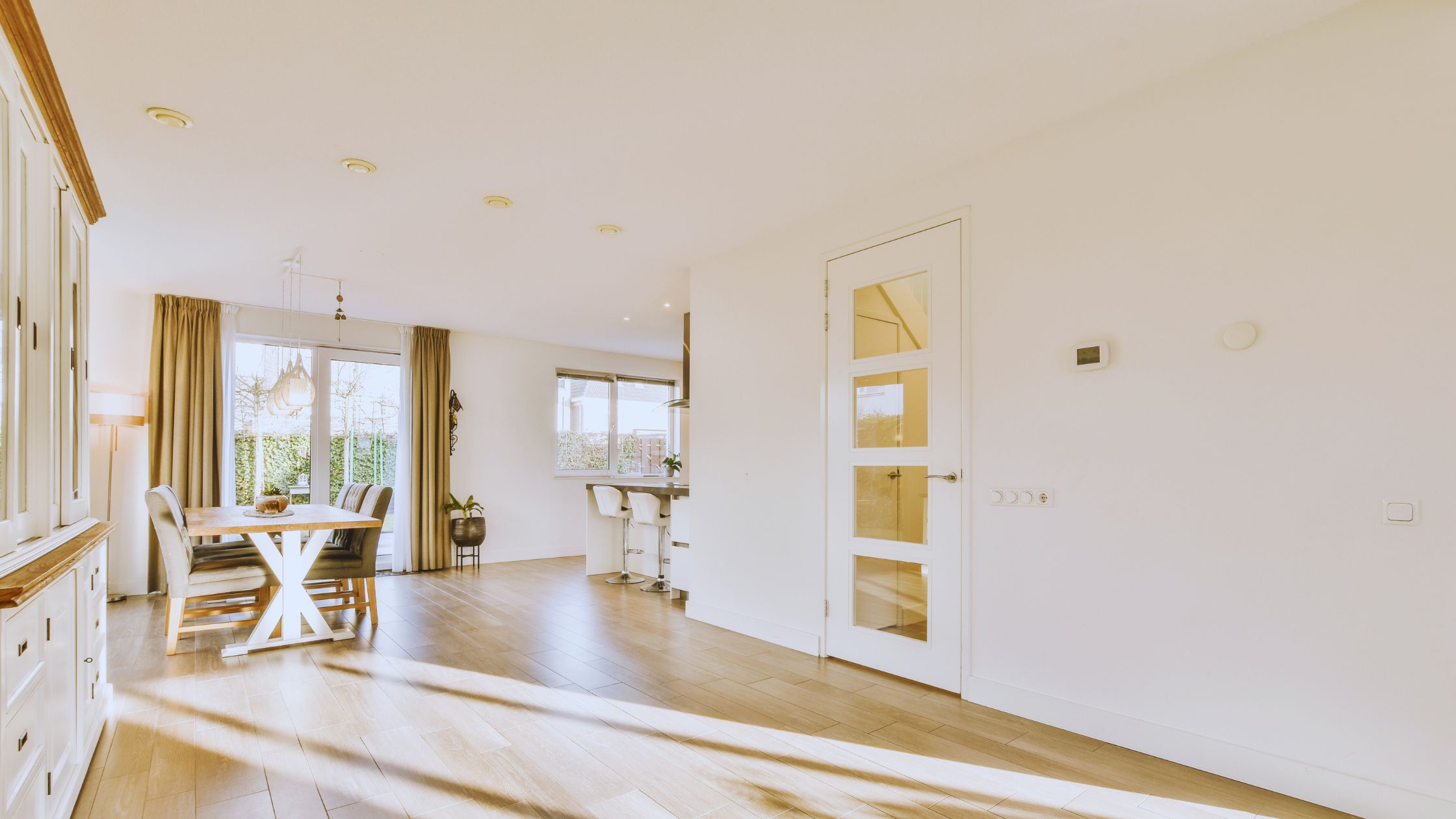 "A modern suburban home with a spacious driveway and double garage, set against a vibrant sunset sky, featuring well-maintained landscaping and a cozy porch light illuminating the entryway.