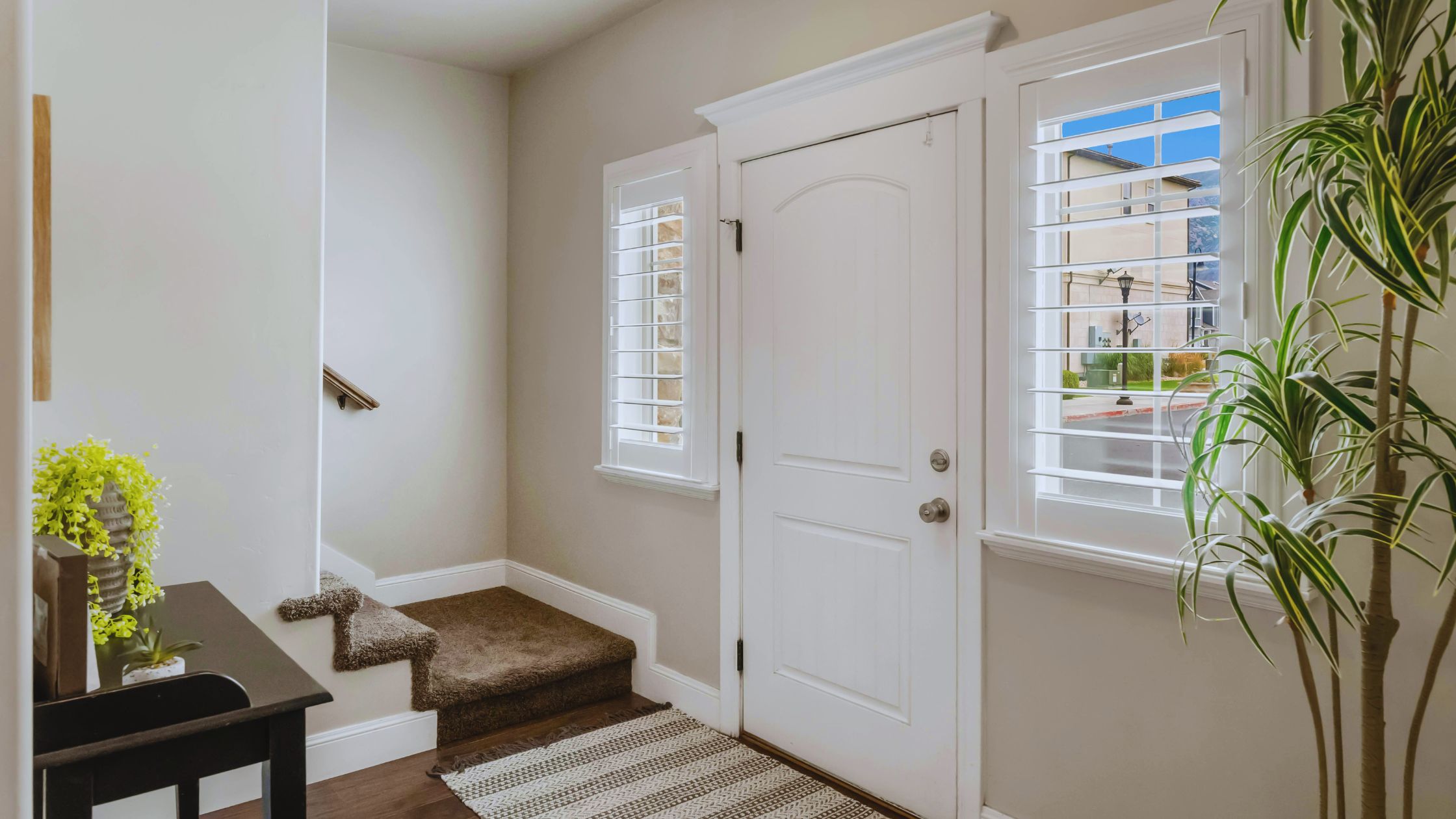 "A modern suburban home with a spacious driveway and double garage, set against a vibrant sunset sky, featuring well-maintained landscaping and a cozy porch light illuminating the entryway.
