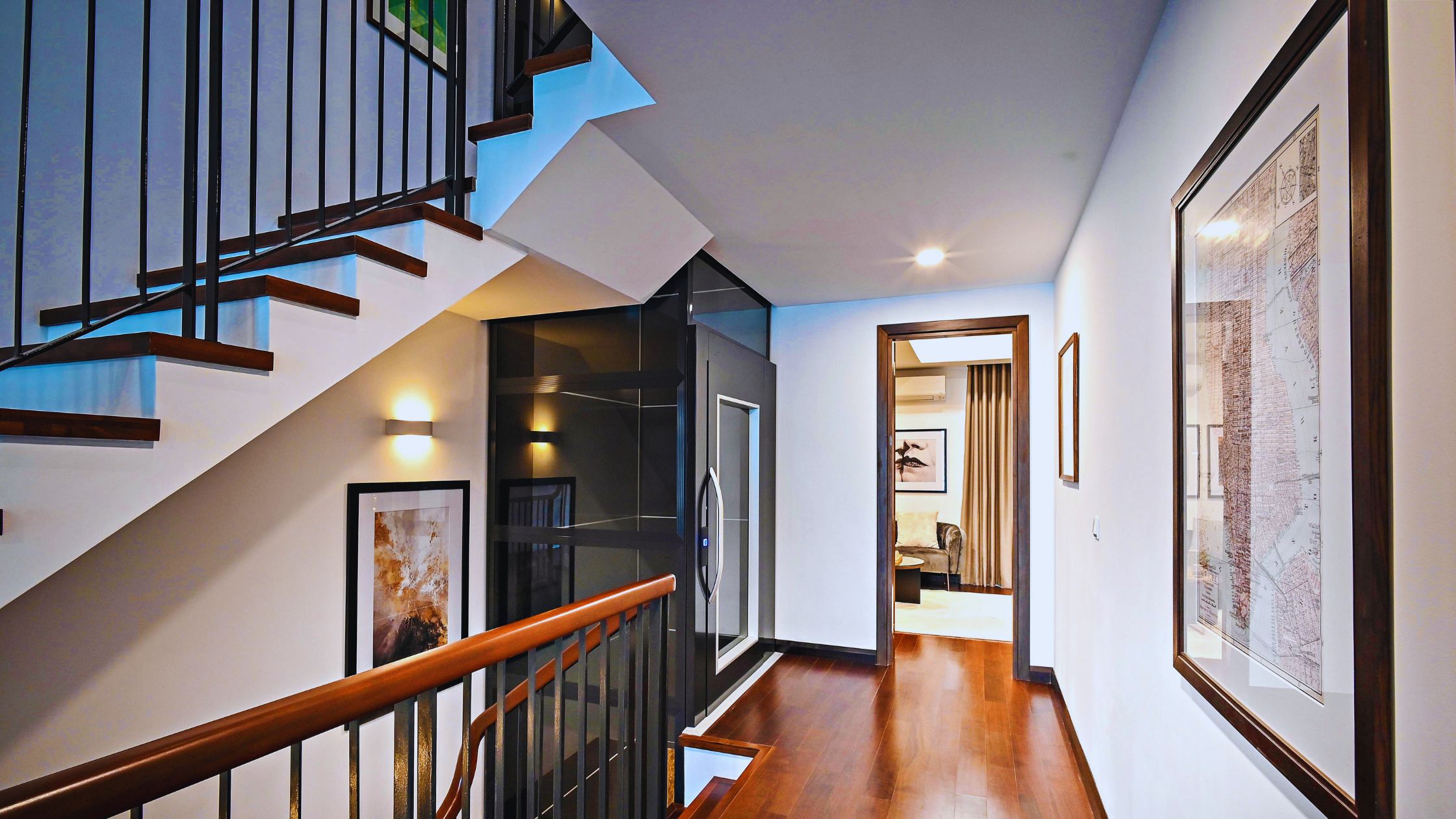 "A modern suburban home with a spacious driveway and double garage, set against a vibrant sunset sky, featuring well-maintained landscaping and a cozy porch light illuminating the entryway.