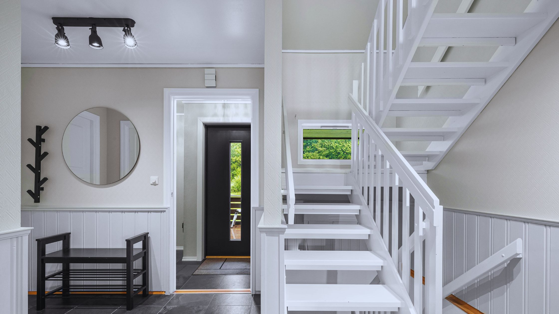 "A modern suburban home with a spacious driveway and double garage, set against a vibrant sunset sky, featuring well-maintained landscaping and a cozy porch light illuminating the entryway.