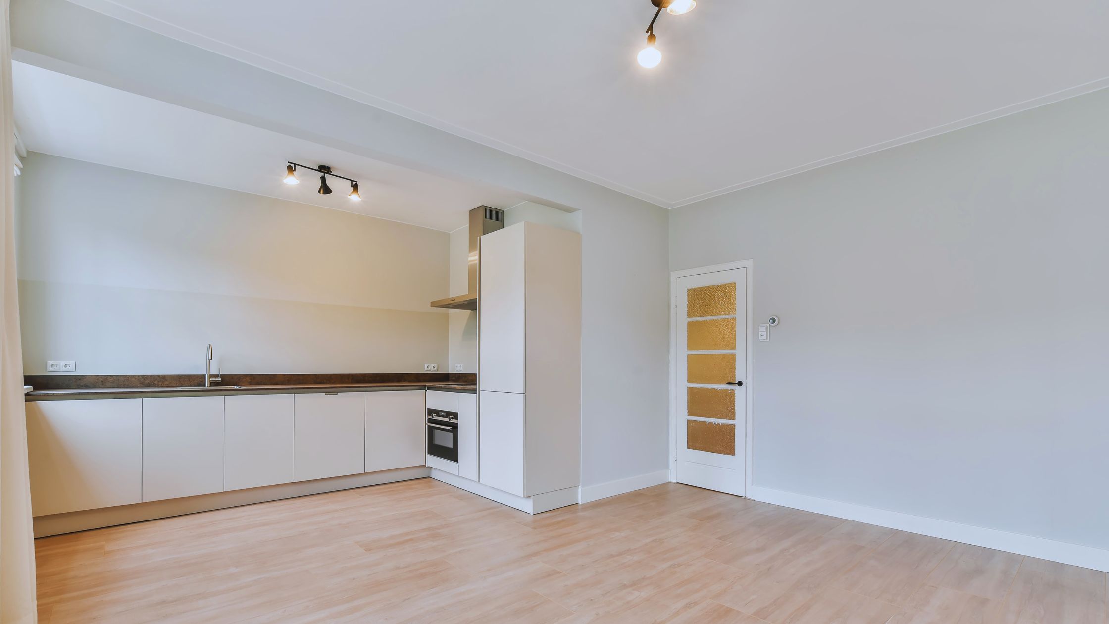 "A modern suburban home with a spacious driveway and double garage, set against a vibrant sunset sky, featuring well-maintained landscaping and a cozy porch light illuminating the entryway.