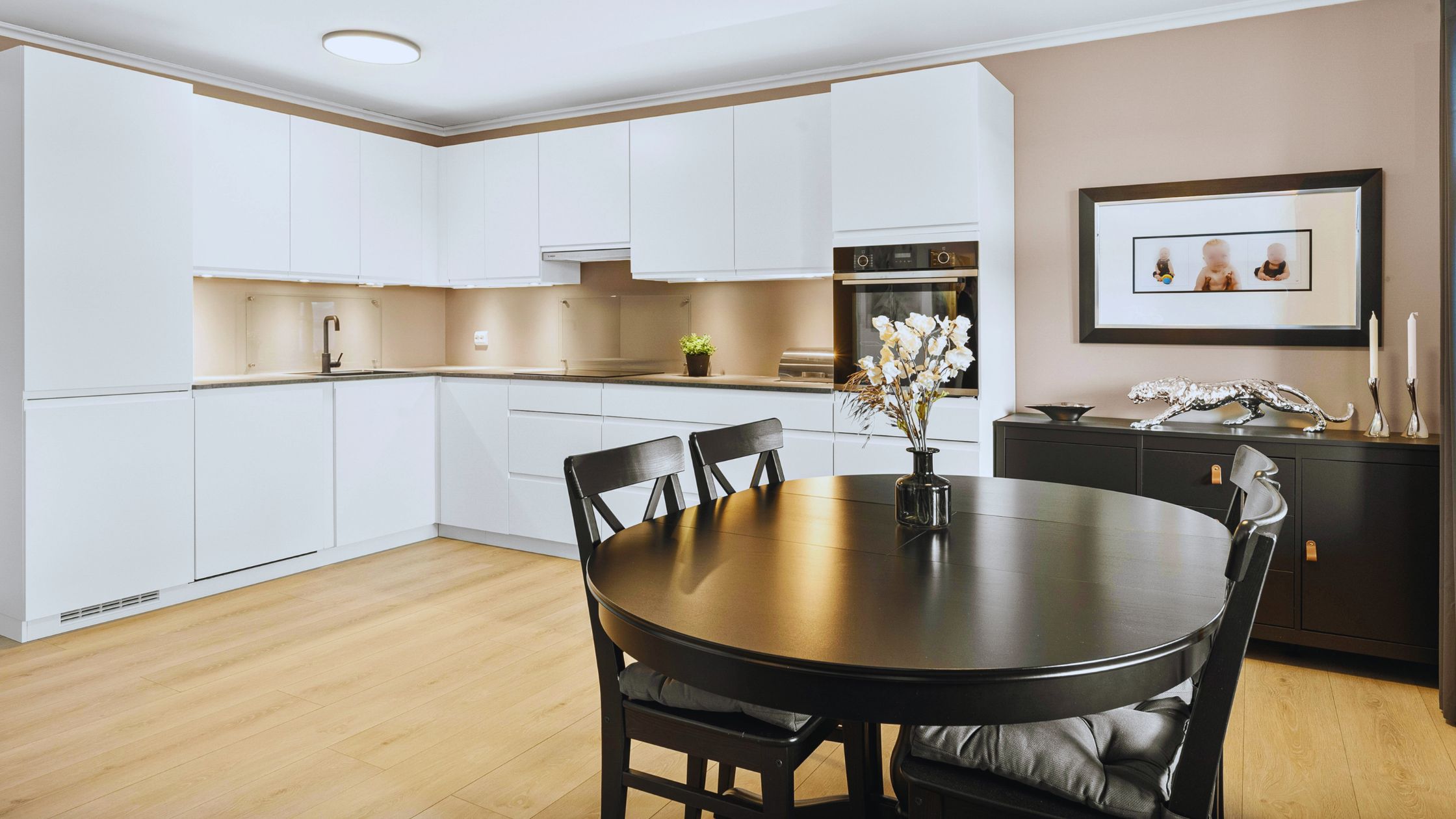 "A modern suburban home with a spacious driveway and double garage, set against a vibrant sunset sky, featuring well-maintained landscaping and a cozy porch light illuminating the entryway.