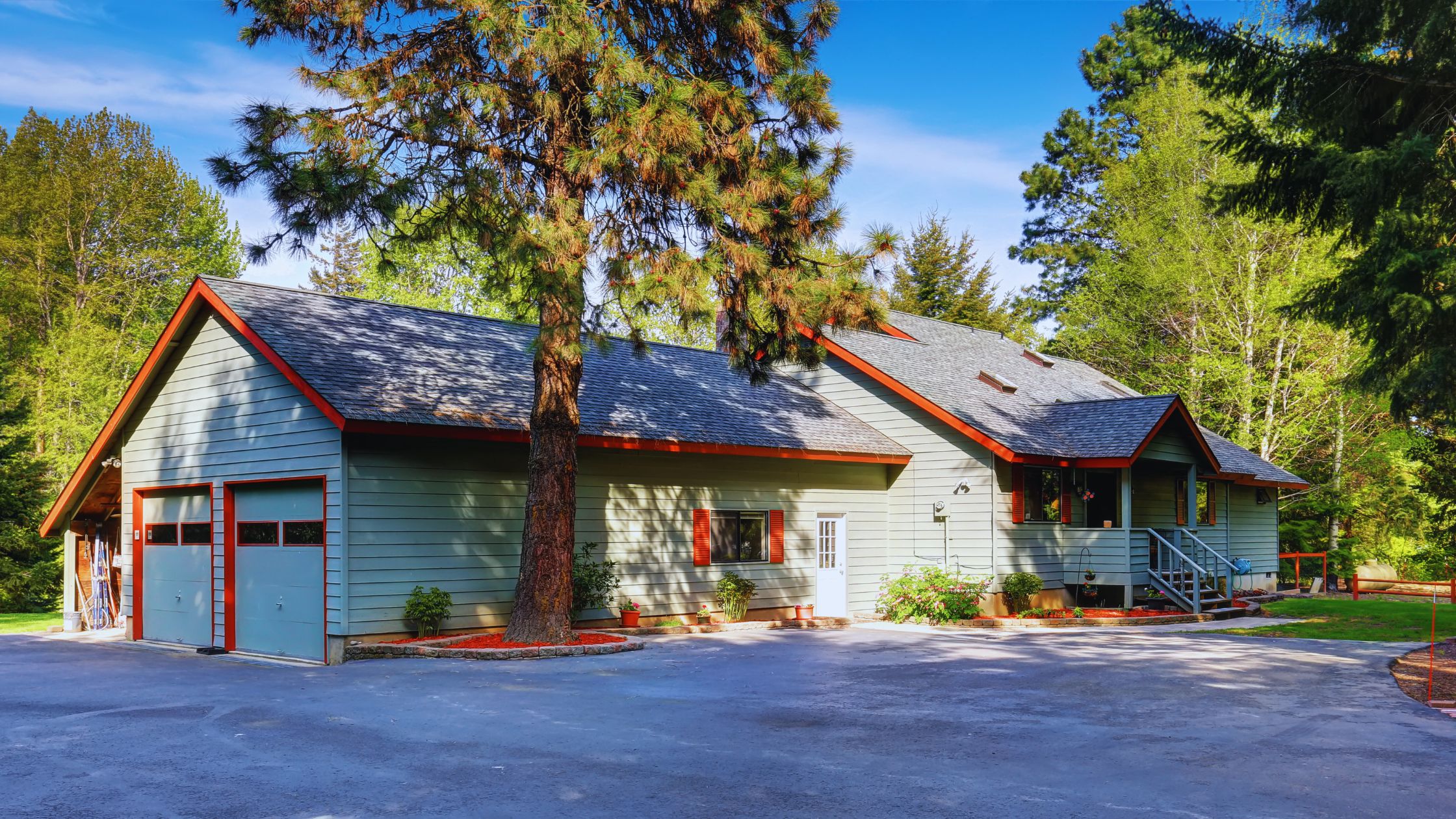 "A modern suburban home with a spacious driveway and double garage, set against a vibrant sunset sky, featuring well-maintained landscaping and a cozy porch light illuminating the entryway.