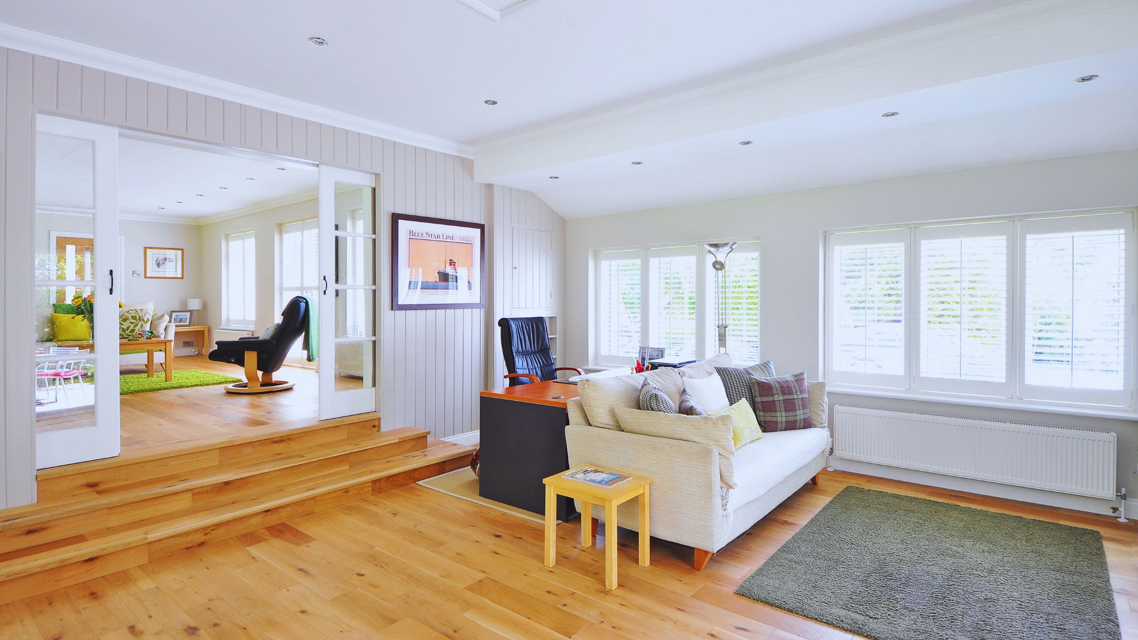 "A modern suburban home with a spacious driveway and double garage, set against a vibrant sunset sky, featuring well-maintained landscaping and a cozy porch light illuminating the entryway.