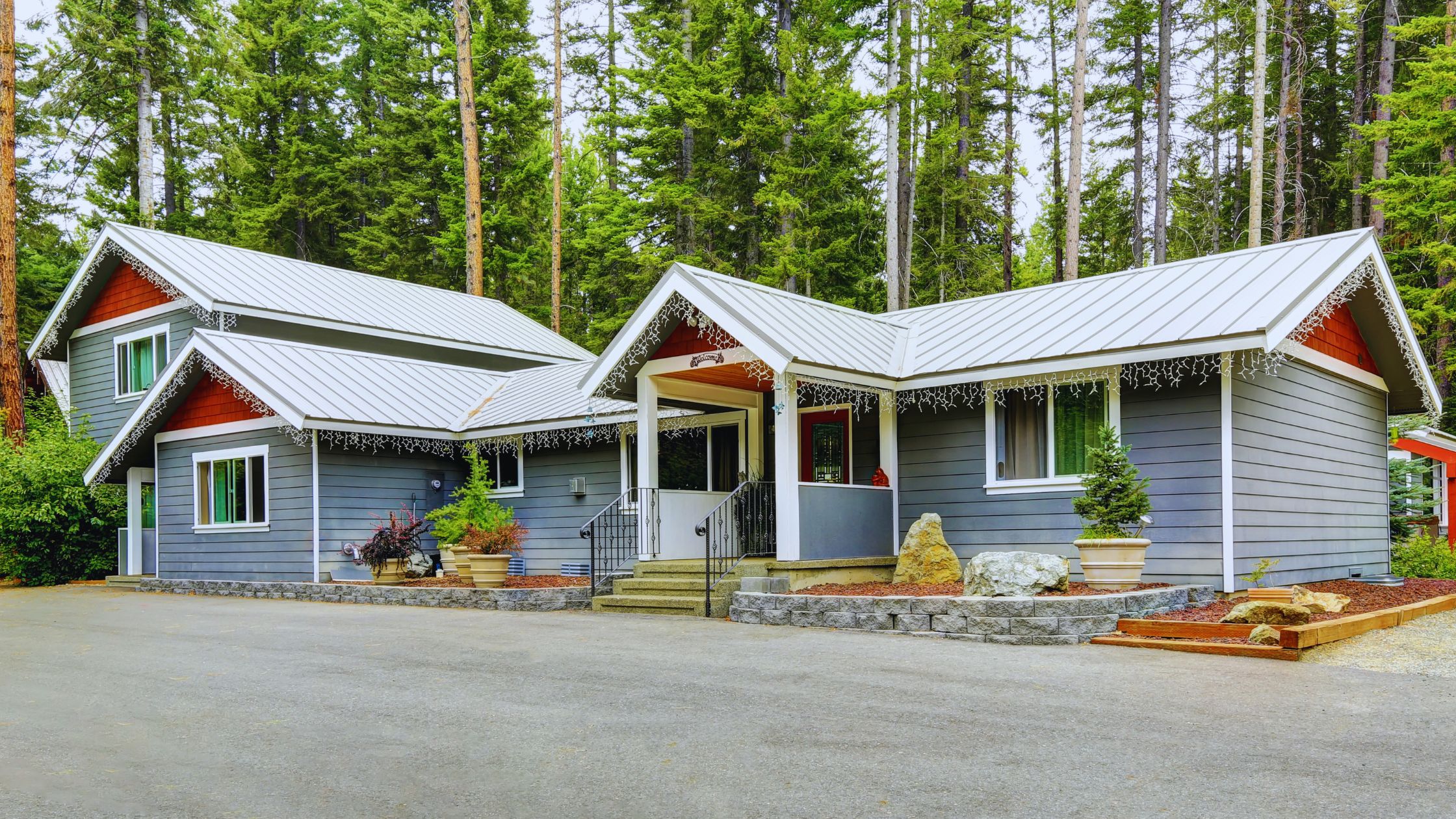"A modern suburban home with a spacious driveway and double garage, set against a vibrant sunset sky, featuring well-maintained landscaping and a cozy porch light illuminating the entryway.