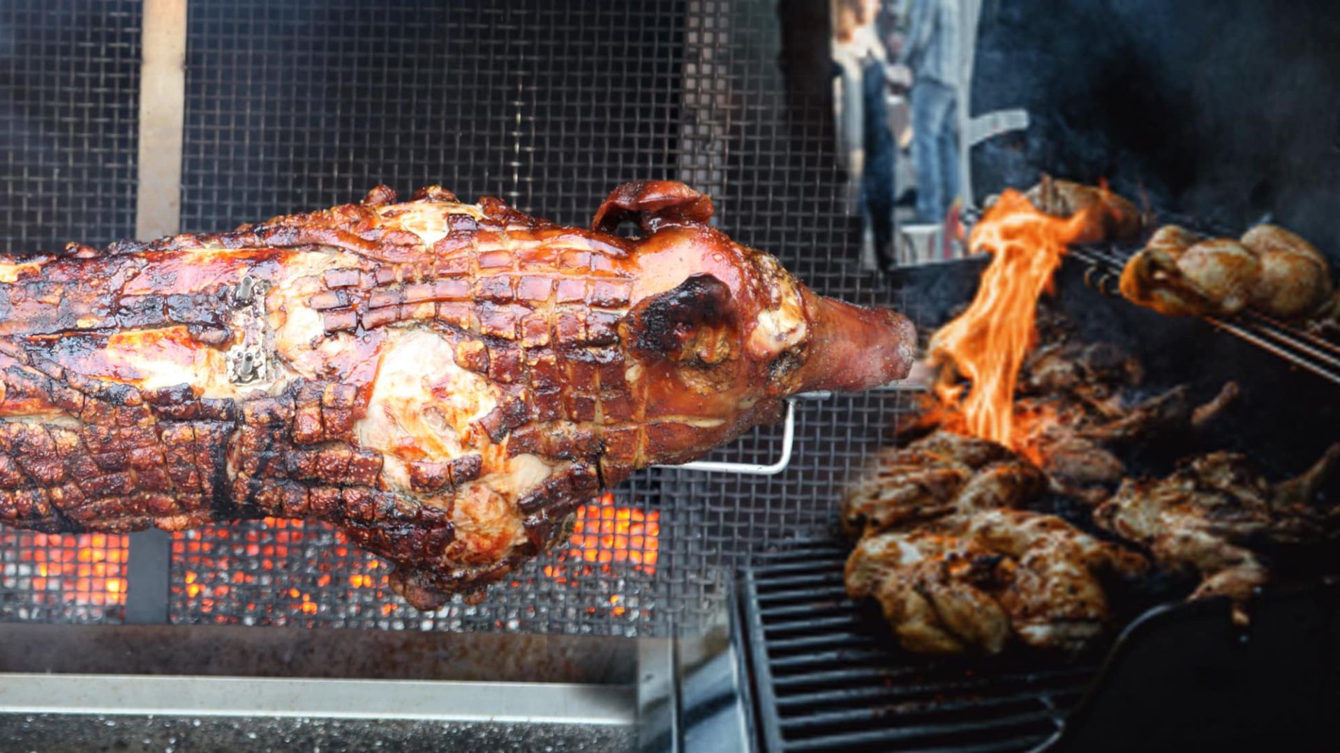 Spanferkel und Fleischstücke braten über offenem Feuer